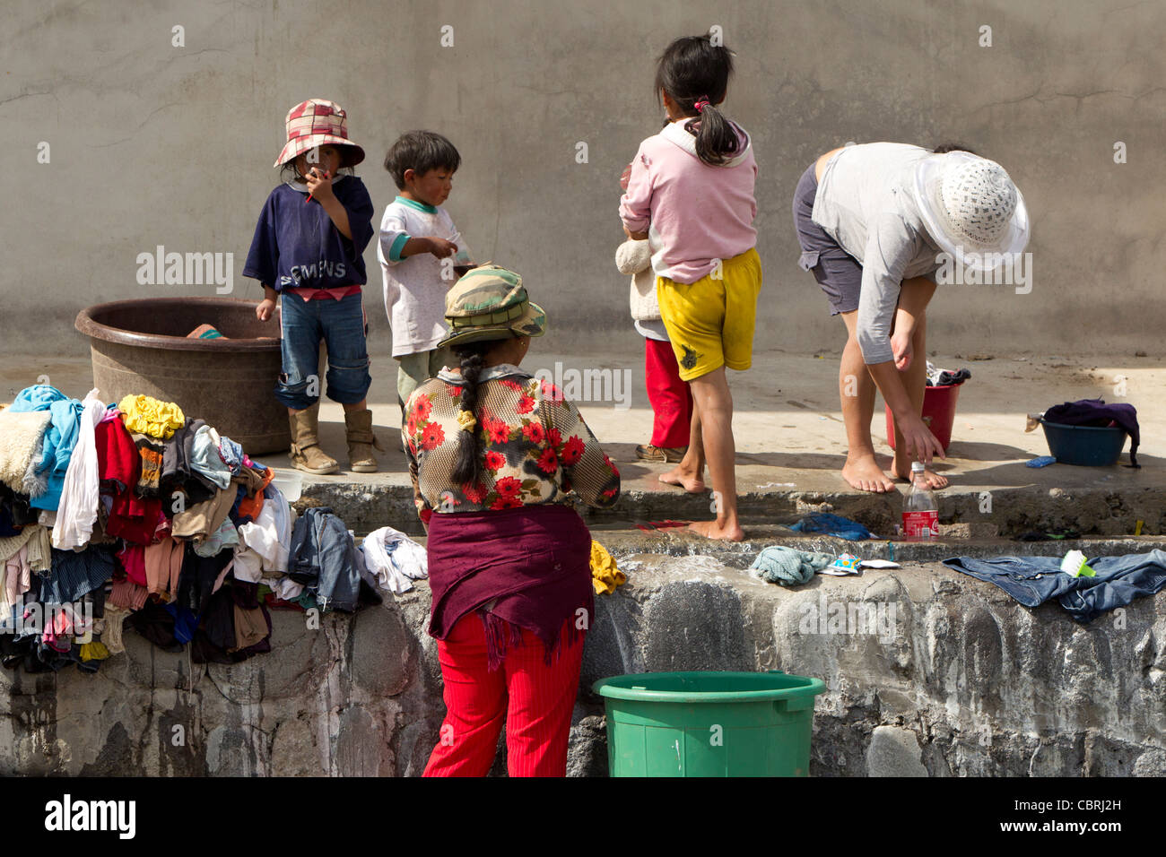 Poor People Washing Their Clothing On The Street Due To Lack Of Basic Utilities Stock Photo