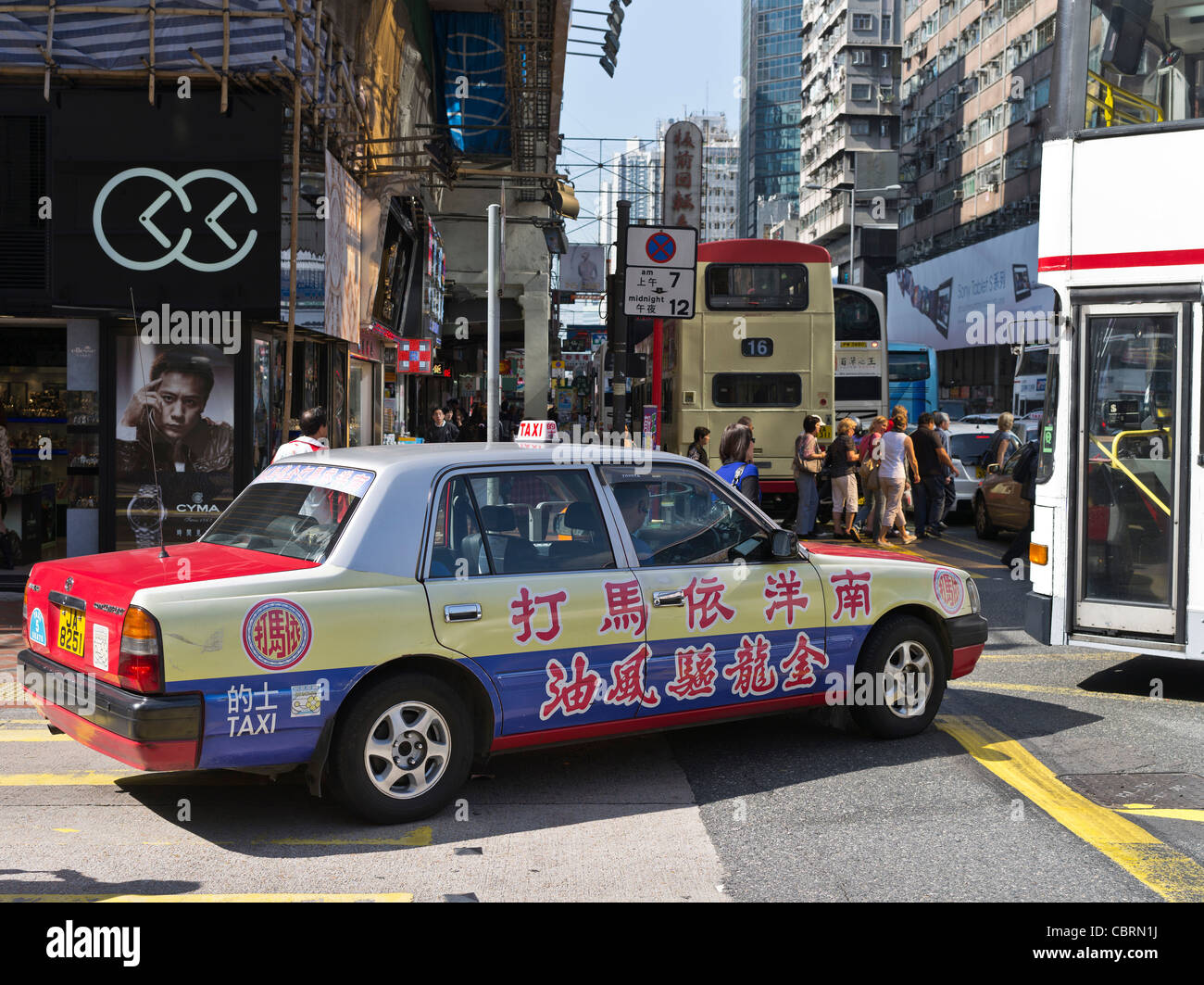 dh  MONG KOK HONG KONG Red Taxi with calligraphy advert in crowded traffic busy street people Stock Photo