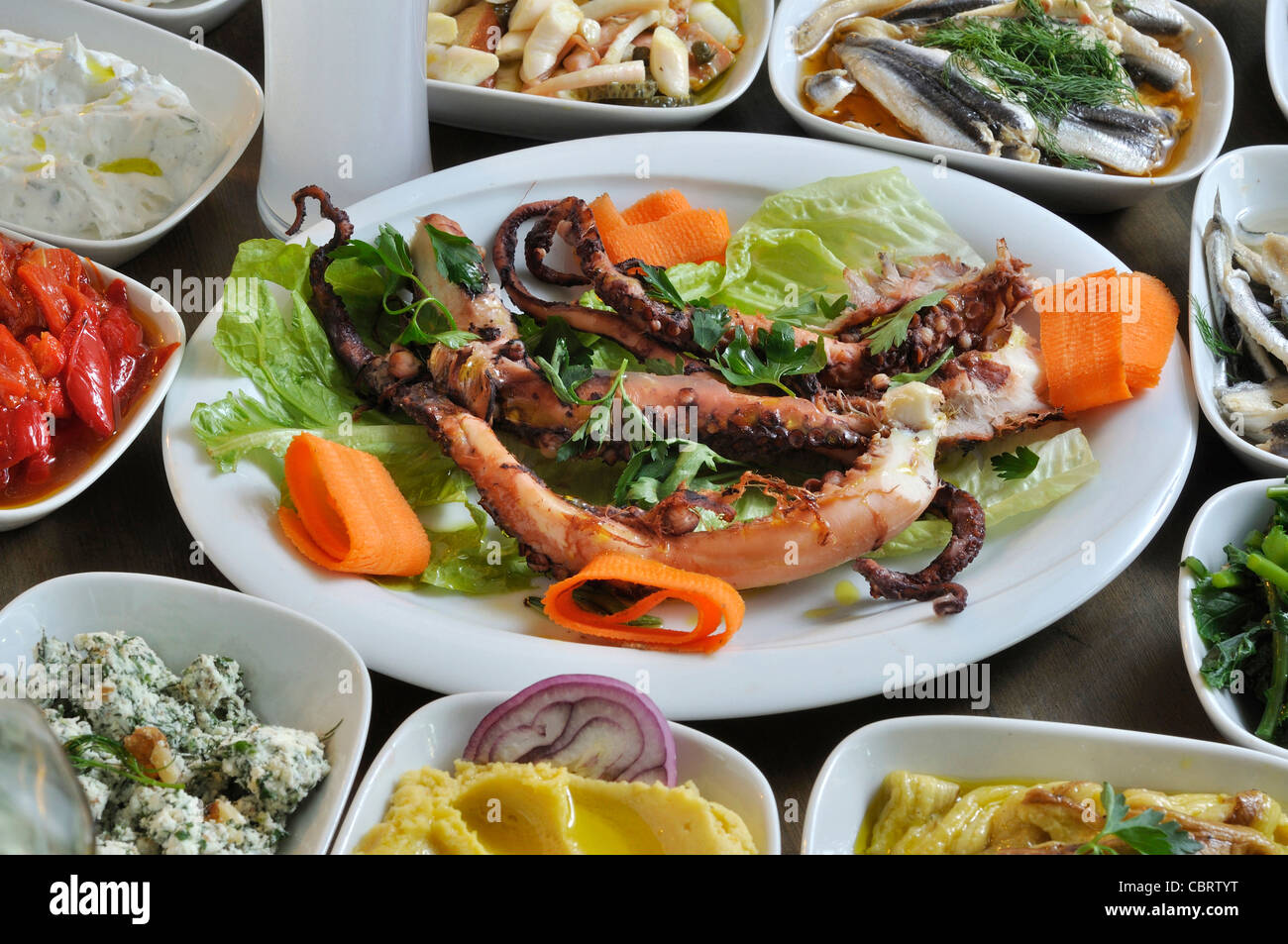 different kinds of Turkish and Greek snacks on the dinner table with traditional drink akı and ouzo Stock Photo