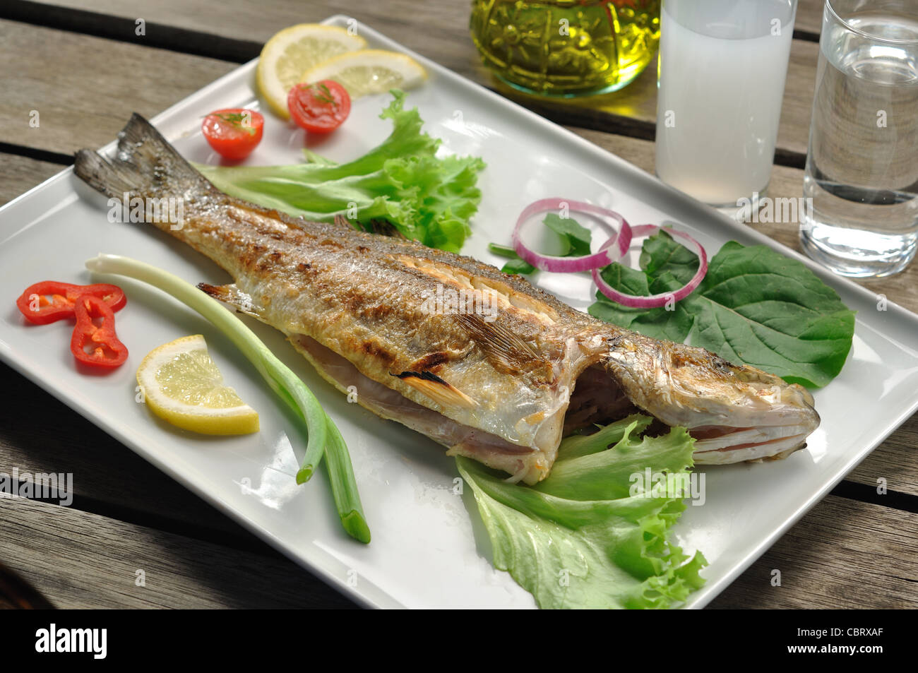 char grilled sea bass fish served with garnish and traditional Greek