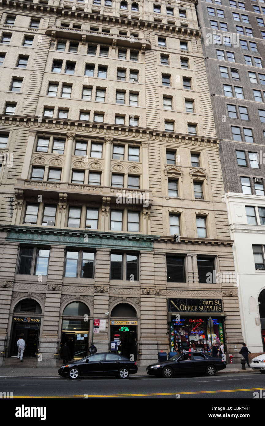 Black cars parked people walking man entering Duane Reade Office