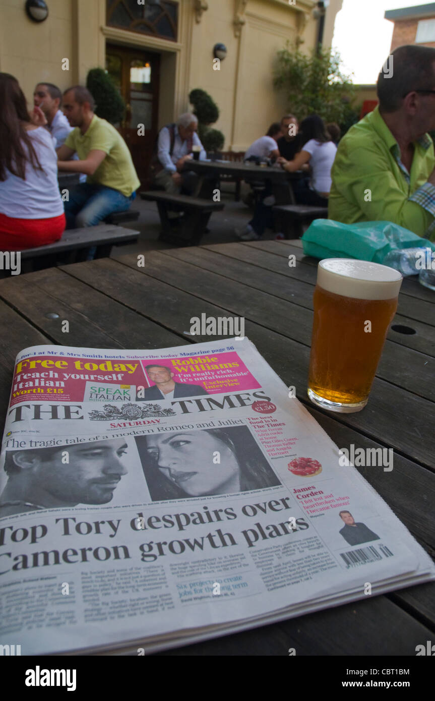 The Times newspaper and pint of bitter beer Earl of Lonsdale pub couryard beer garden Notting