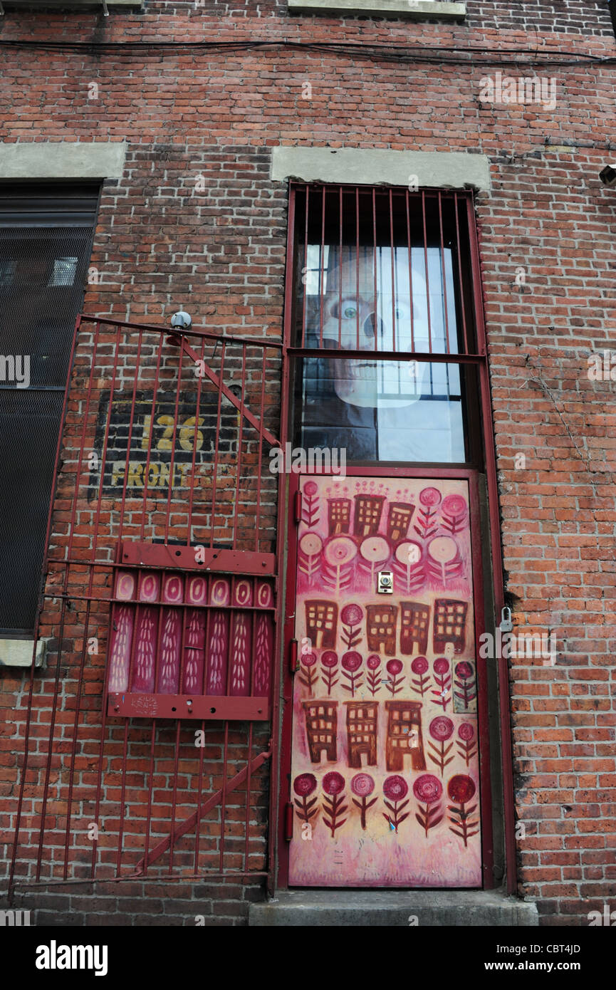 Red brick portrait spooky skull red flowers industrial doorway, Superfine Restaurant, Front Street, Brooklyn Dumbo, New York Stock Photo
