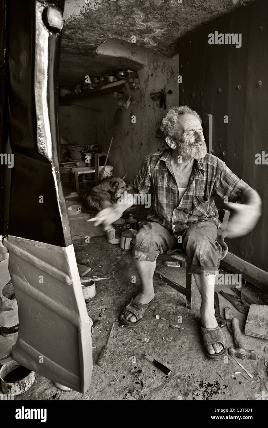 An old fisherman, describing the sea inside his 'syrma', Mandrakia village, Milos island, Greece. (B&w version) Stock Photo