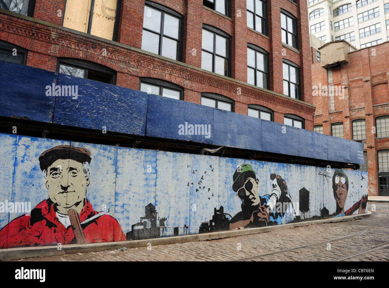 Artist Chris Stain's wall painting of 3 workers from Dumbo's industrial past, Plymouth Street at Washington Street, Brooklyn, NY Stock Photo
