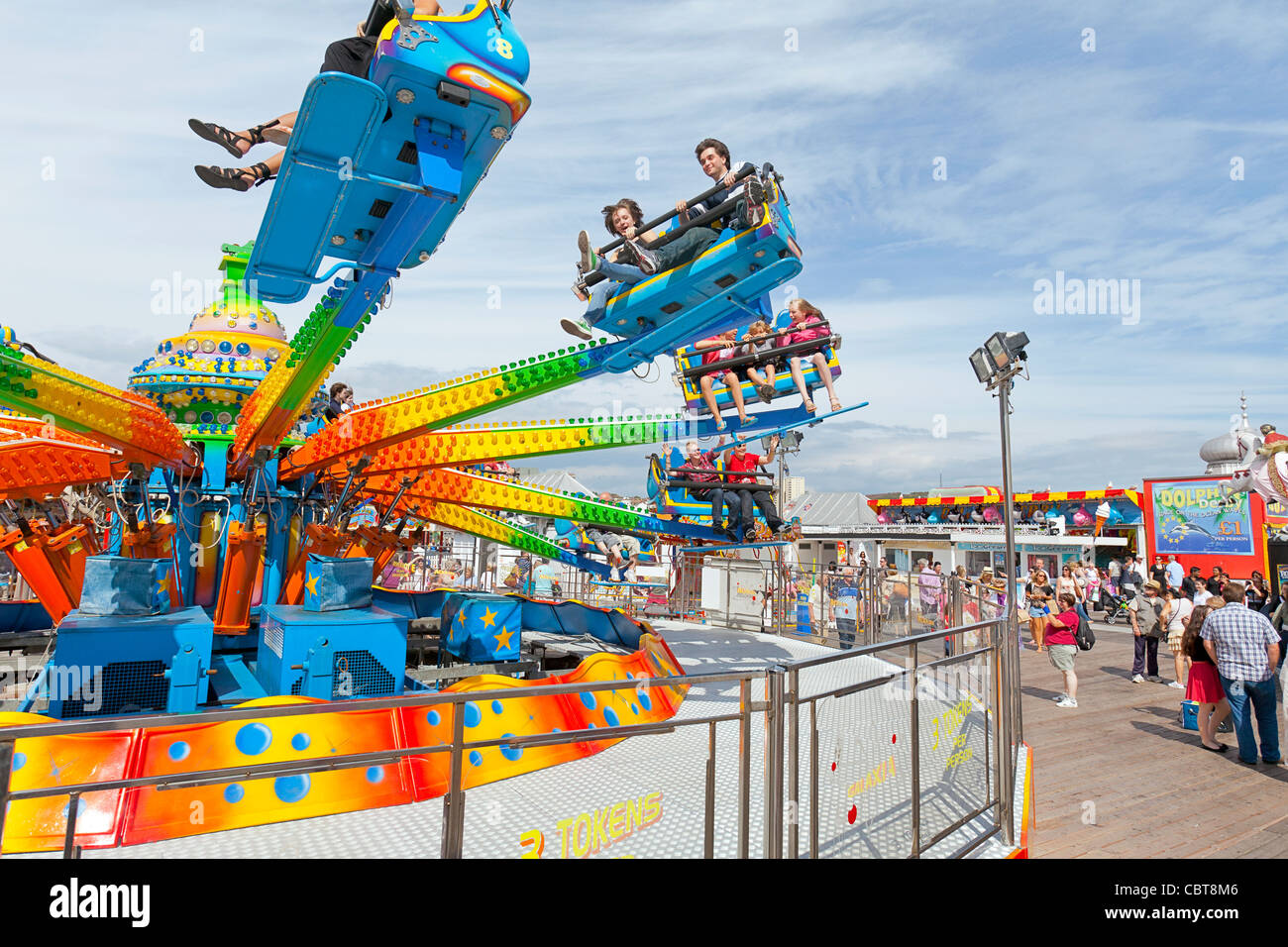 People on holiday and vacation enjoying themselves on amusement park rides on Brighton Pier. Stock Photo