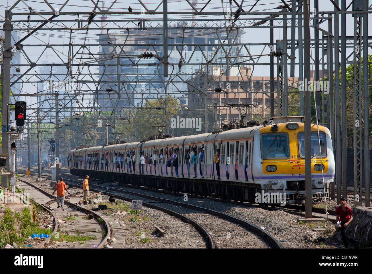 Office workers on crowded commuter train of Western Railway near Mahalaxmi Station on the Mumbai Suburban Railway, India Stock Photo