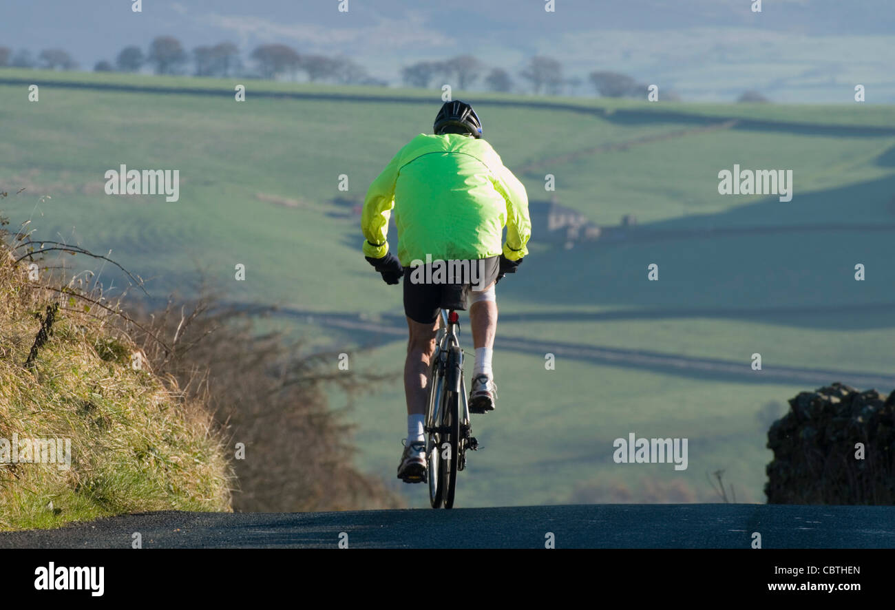 cyclist on country road near Pendle Hill Lancashire Stock Photo