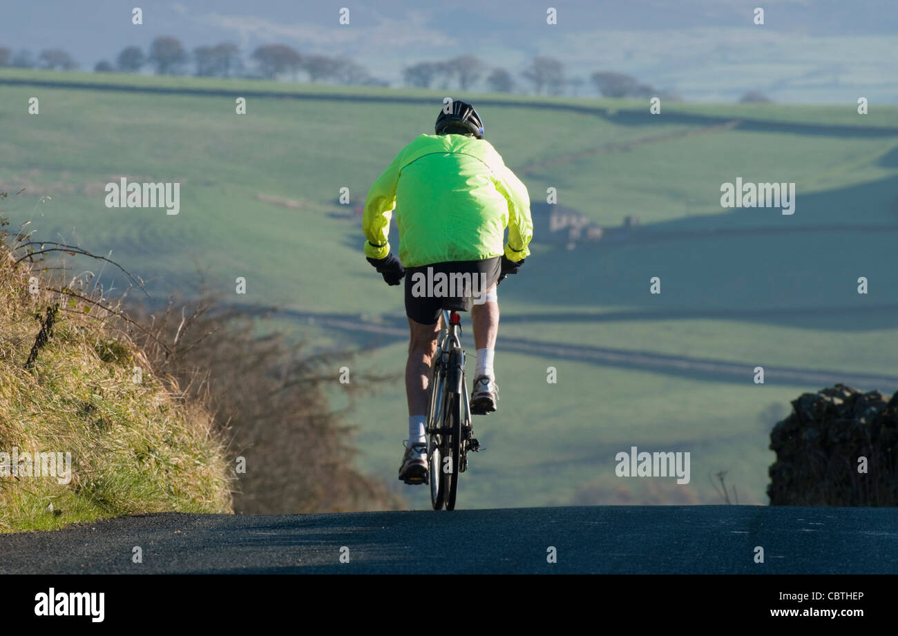 cyclist on country road near Pendle Hill Lancashire Stock Photo