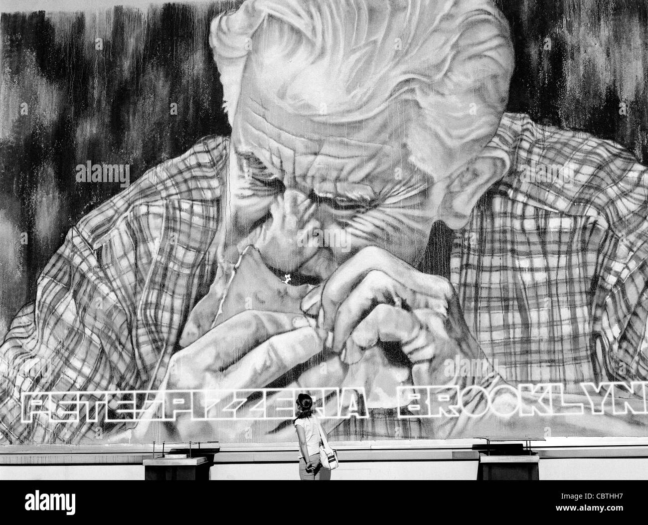 Graffiti depiction of an old man eating a slice of pizza. Stock Photo