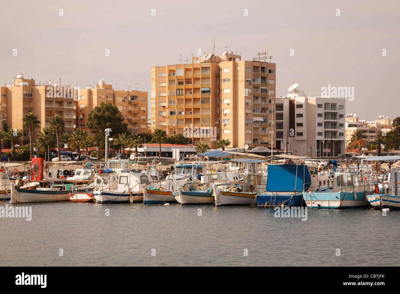 Cypriot fishing boats in the harbour at Larnaca, with tourist hotels behind. Stock Photo