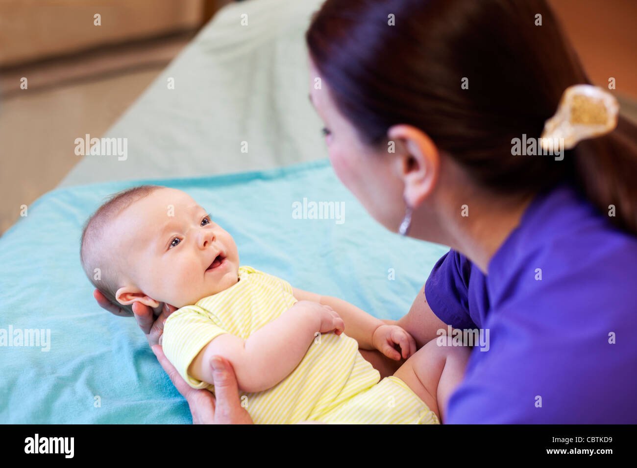 Nurse holding happy healthy infant boy at hospital. Stock Photo