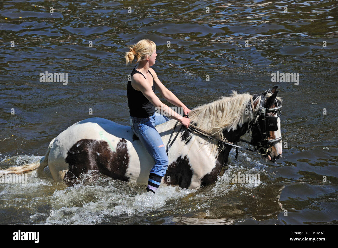 Gypsy traveller girl riding horse in River Eden. Appleby Horse Fair. Appleby-in-Westmorland, Cumbria, England, United Kingdom. Stock Photo