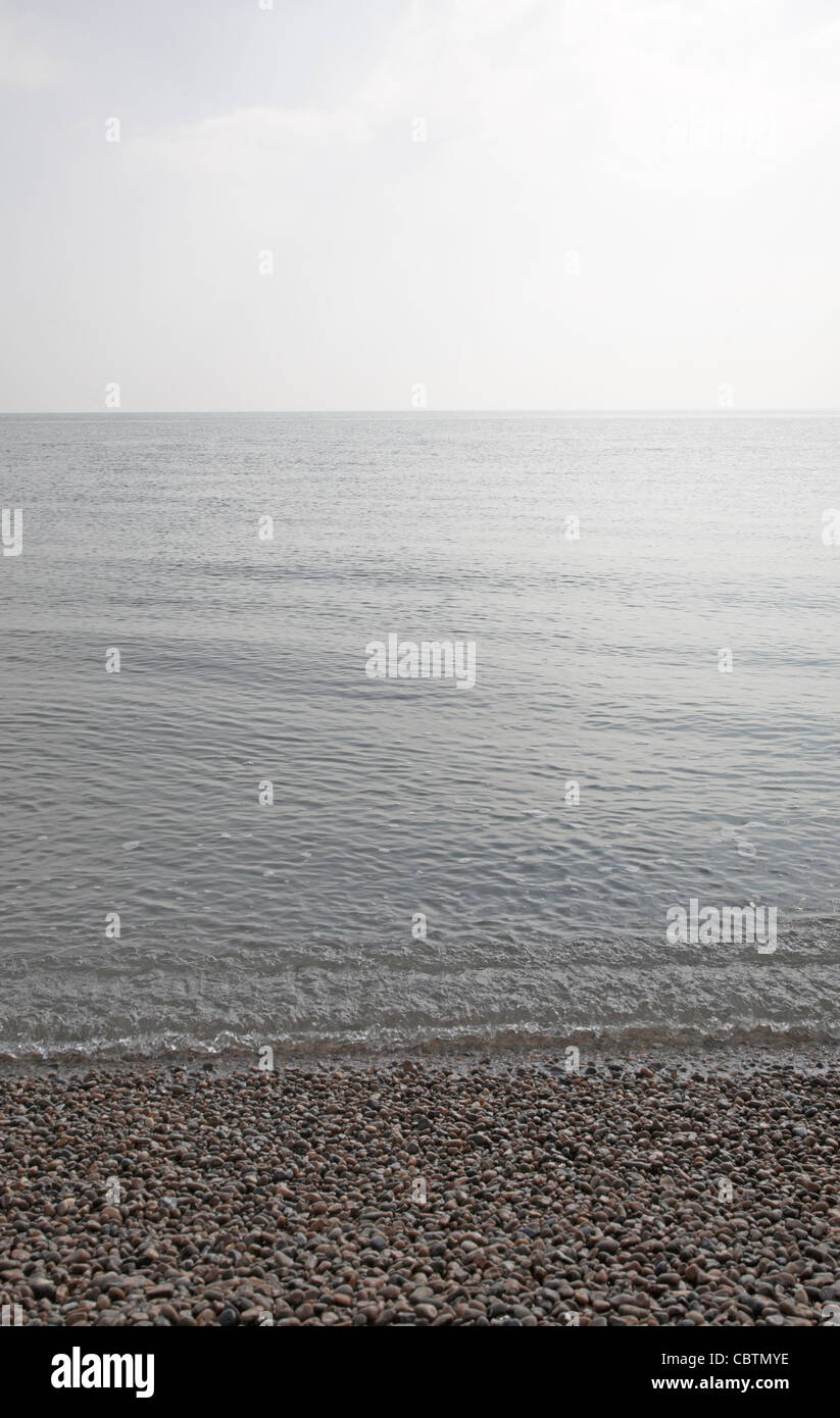 Grey calm water of the North Sea with gentle waves on a still day, from Shingle Street, Suffolk, England Stock Photo