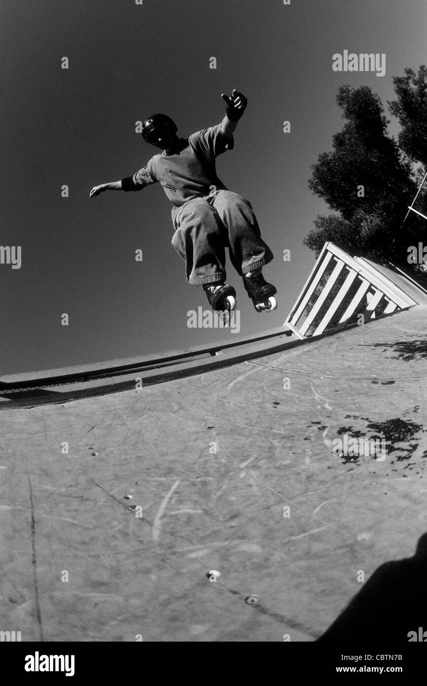 Teenage boy inline skating on the vert ramp Stock Photo - Alamy