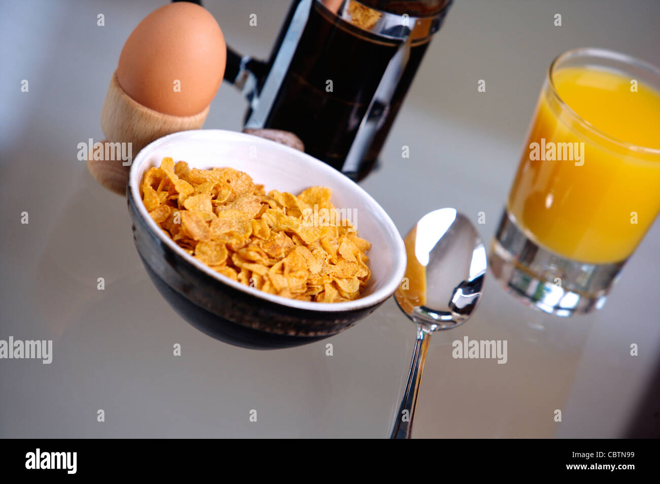 Breakfast cereal on a glass table with coffee, Orange Juice, toast, boiled egg Stock Photo