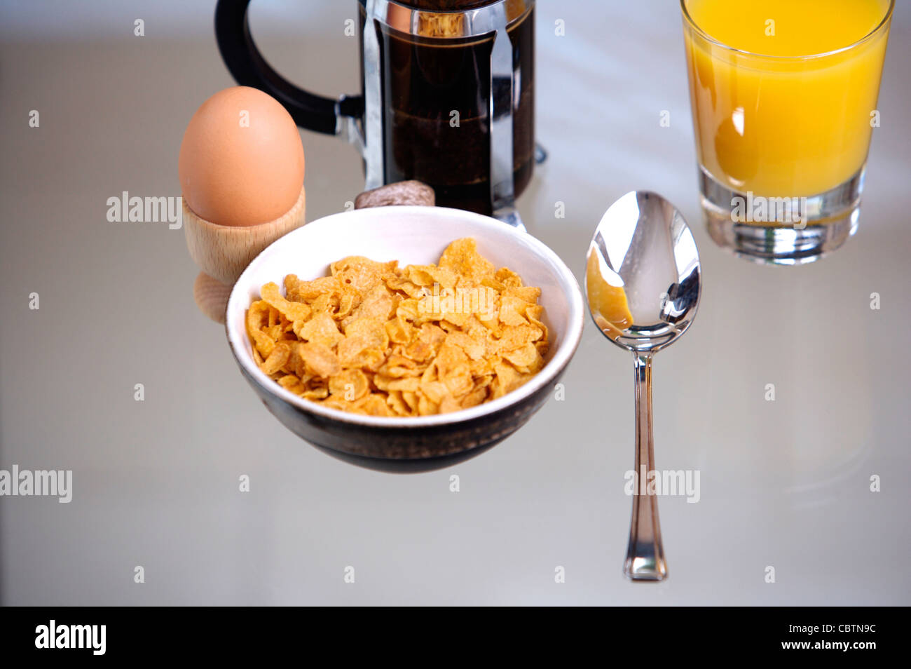 Breakfast cereal on a glass table with coffee, Orange Juice, toast, boiled egg Stock Photo