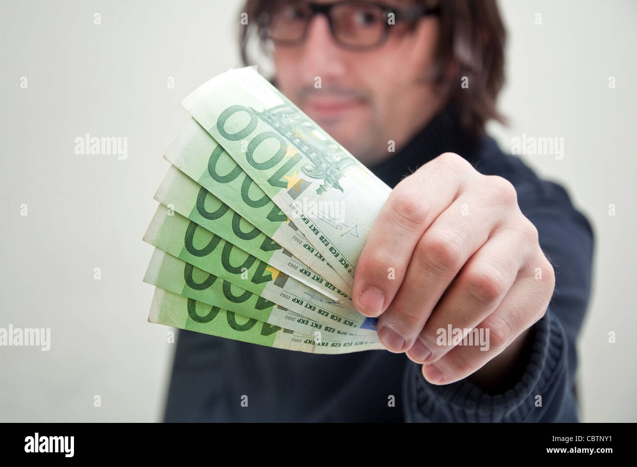 Casual adult man is paying in euros, corruption and bribe concept. Stock Photo