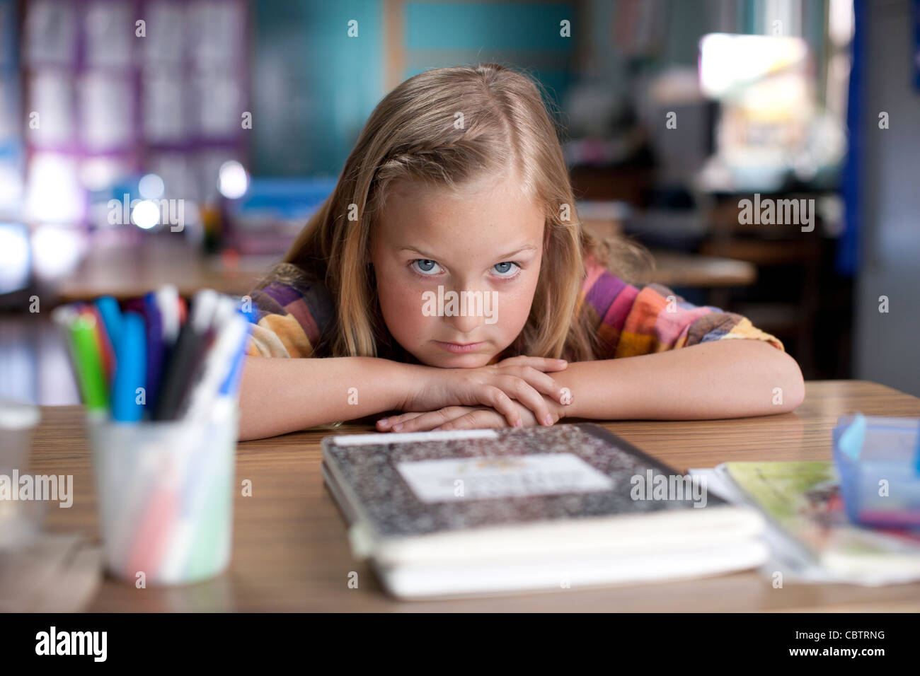 Bored Caucasian girl sitting in classroom Stock Photo