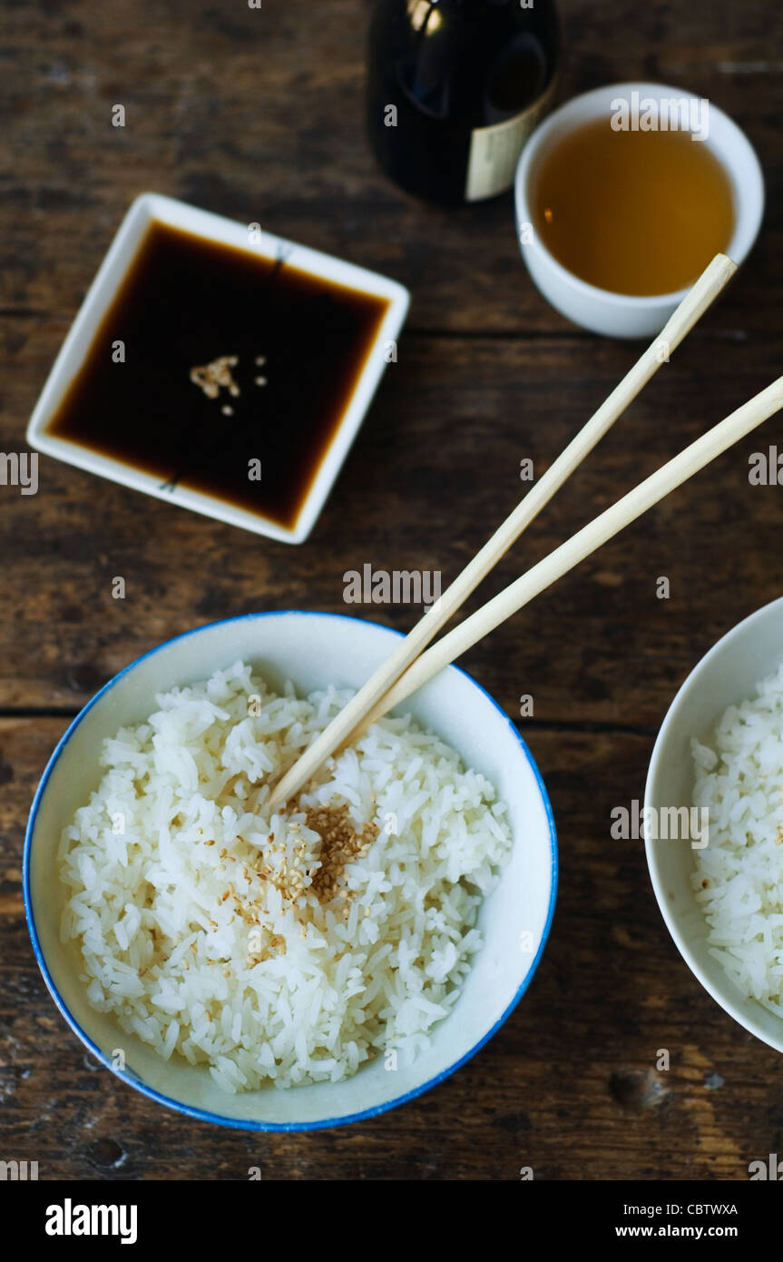 Bowl of rice and chopsticks with sauces Stock Photo