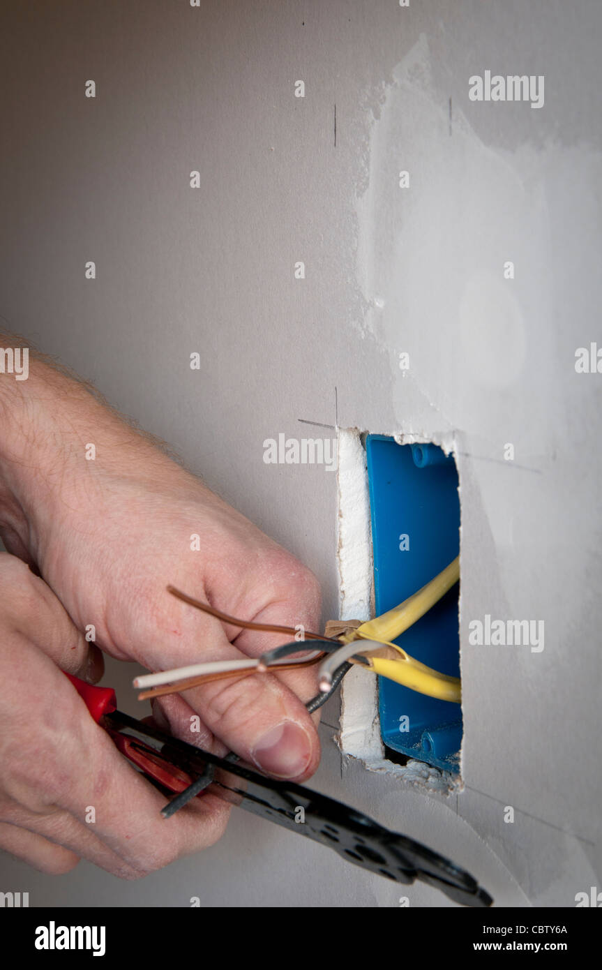 Electrician wiring an electrical receptacle wall socket Stock Photo