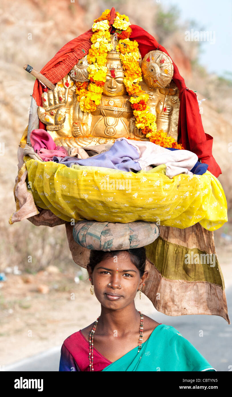Religious indian beggar girl carrying shrine to hindu goddess Gungama