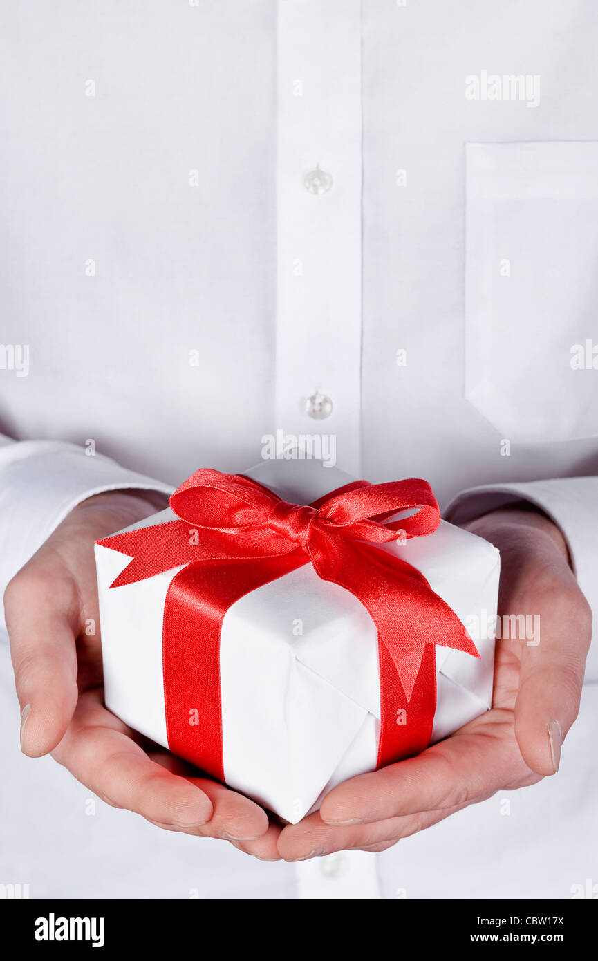 holidays giving, male giving a gift with red ribbon Stock Photo