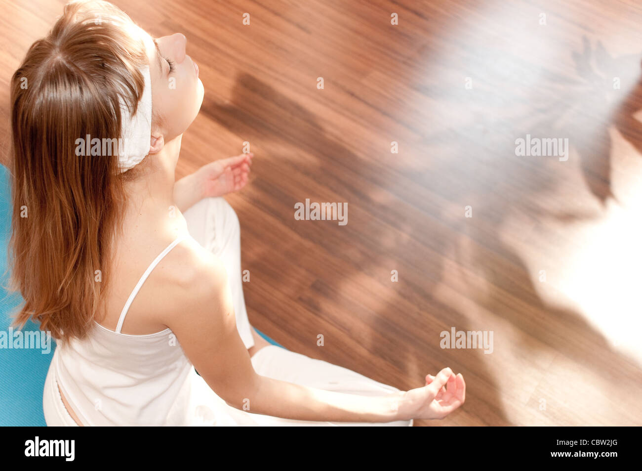 Fit young woman doing yoga exercise sitting in lotus pose Stock Photo ...