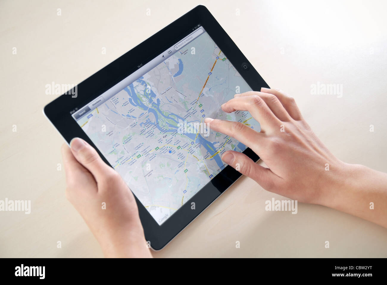Woman hands holding and touching on Apple iPad2 with Google Maps application on a screen. Stock Photo