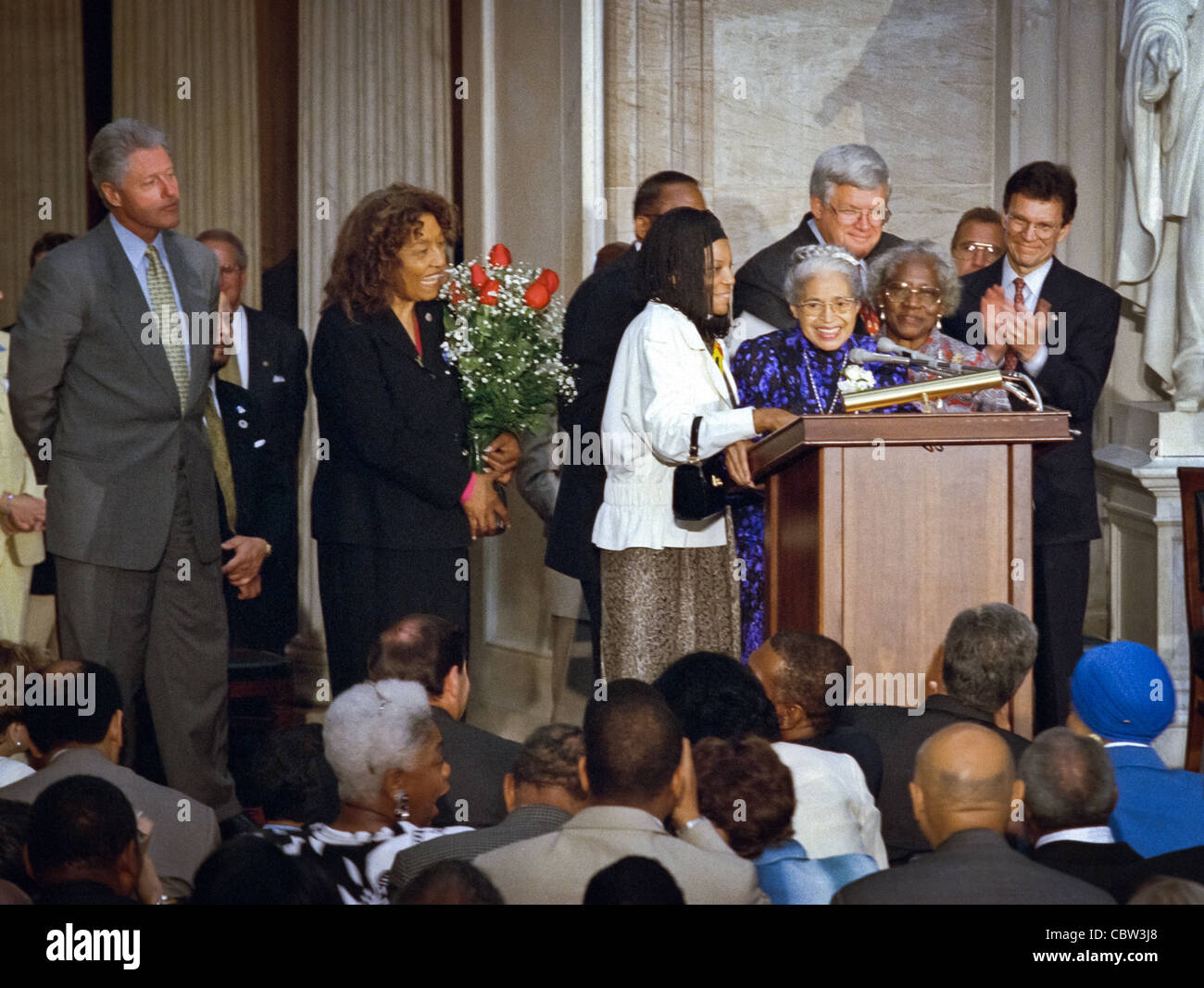 Civil rights heroine Rosa Parks stands at the podium surrounded by President Bill Clinton, US House Speaker Dennis Hastert and her attendant Elaine Steele after being awarded the Congressional Gold Medal June 15, 1999 in Washington, DC. Parks was awarded the Congressional Gold Medal Stock Photo