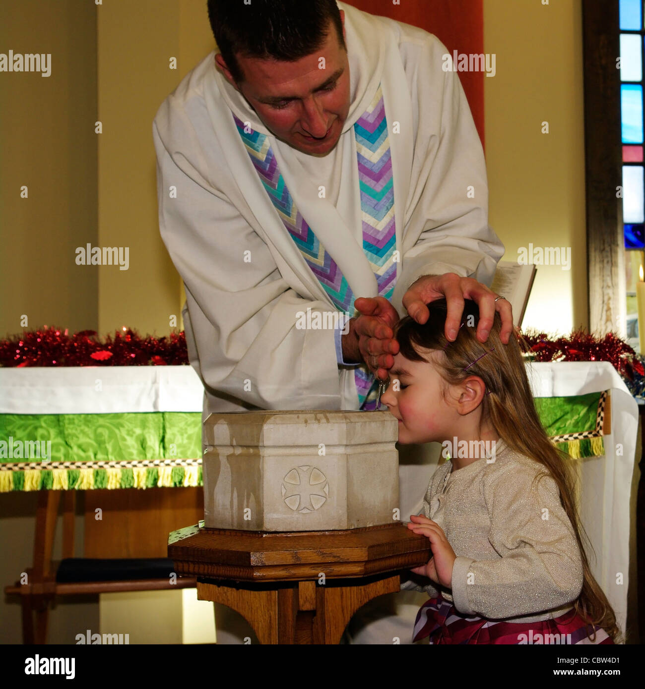 Priest Vicar Baptising Baptizing A young girl Child Christening (release only available for the child) Stock Photo