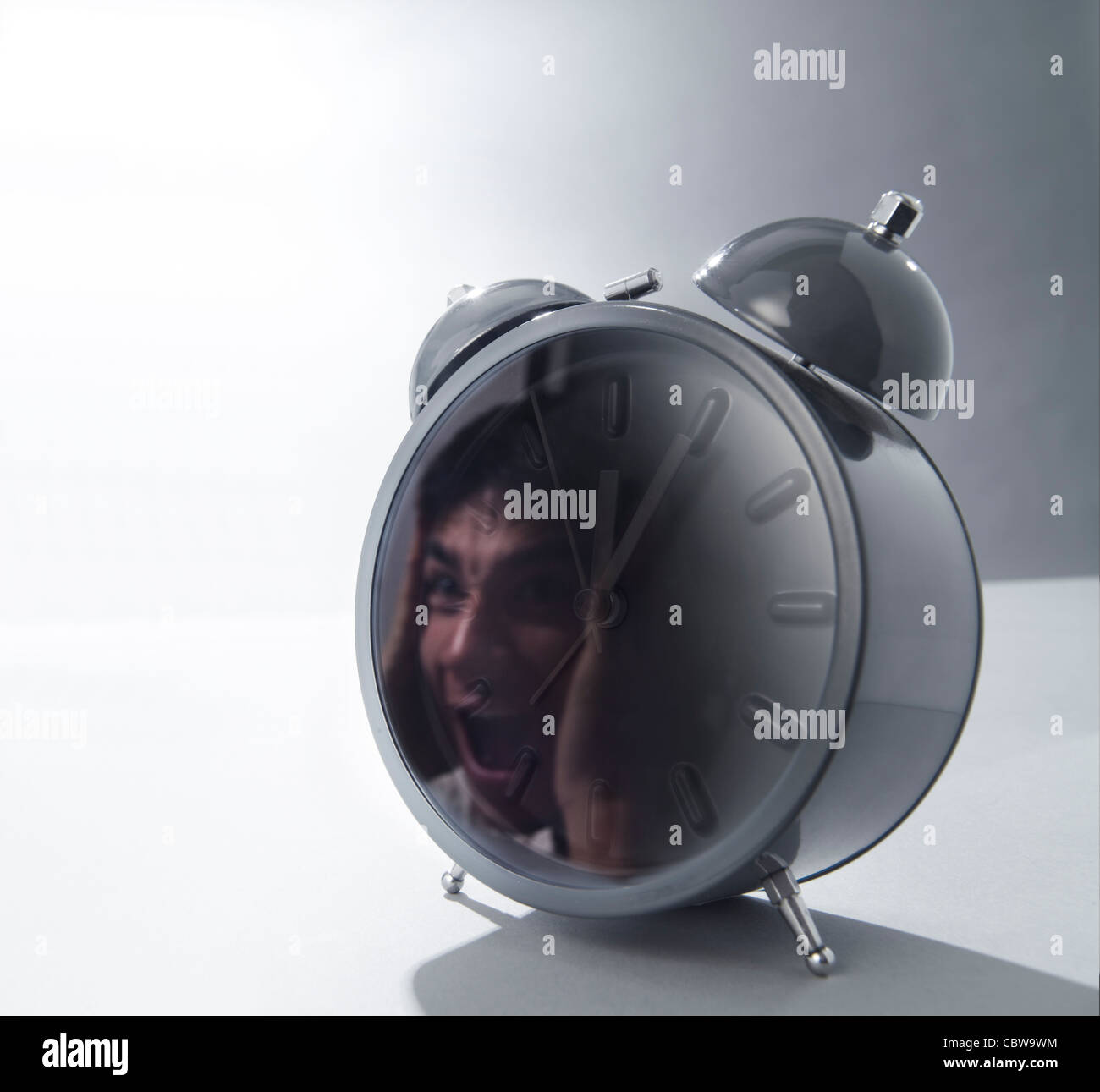 Alarm clock with reflection of screaming man Stock Photo Alamy