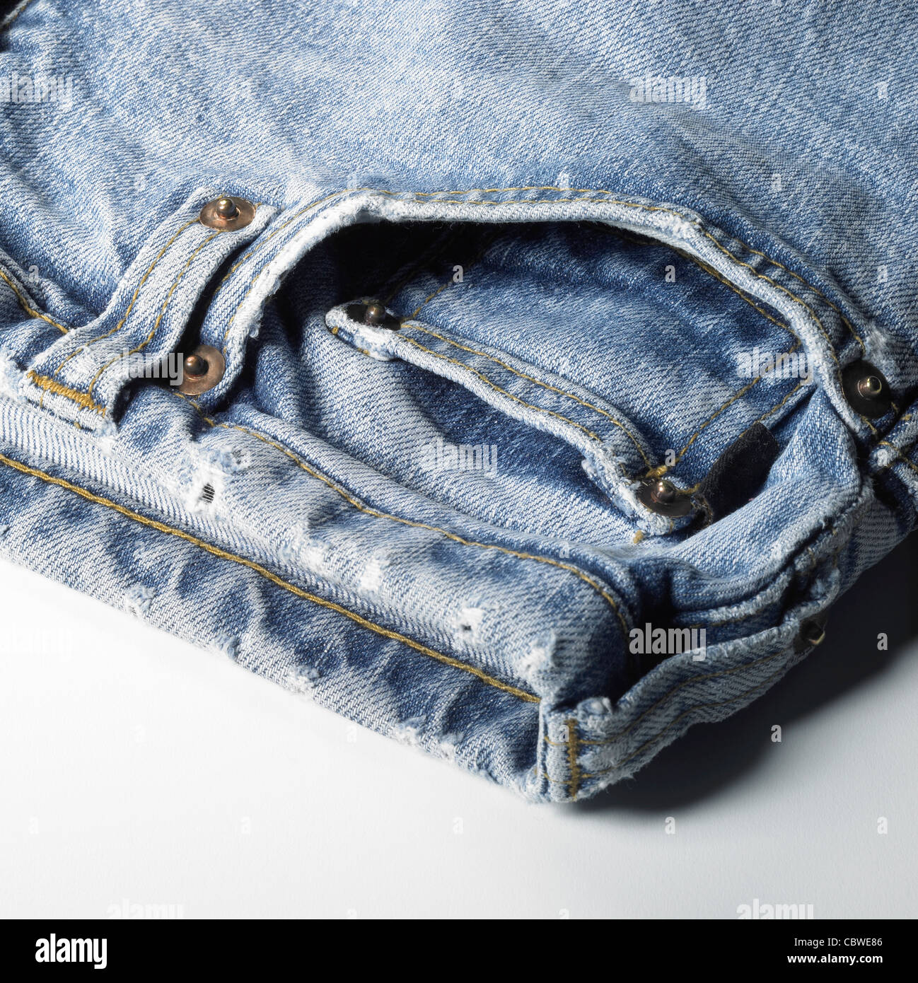 detail studio shot of a used pair of blue jeans in light back Stock Photo