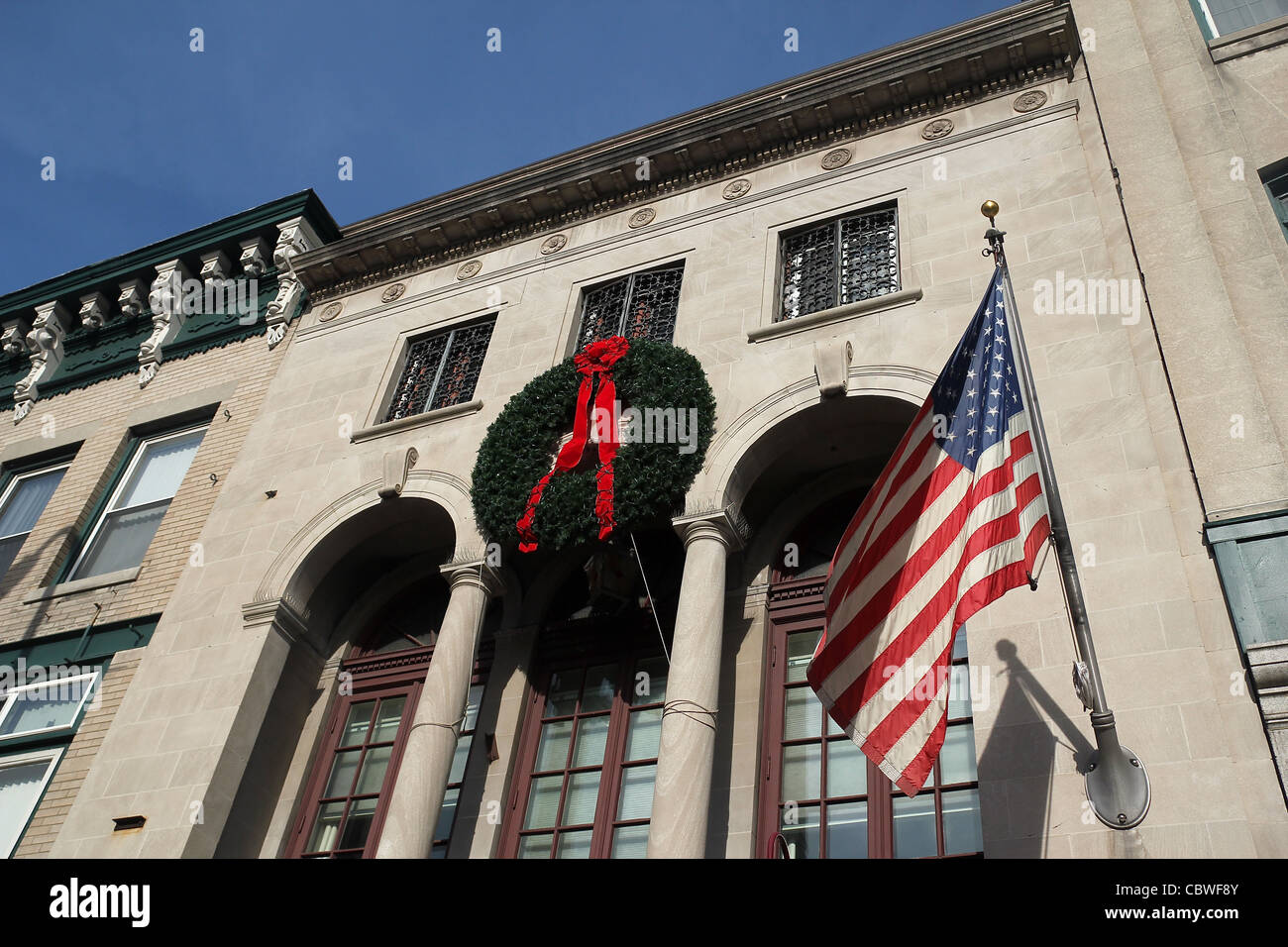 A Christmas wreath and an American flag on the facade of a building in