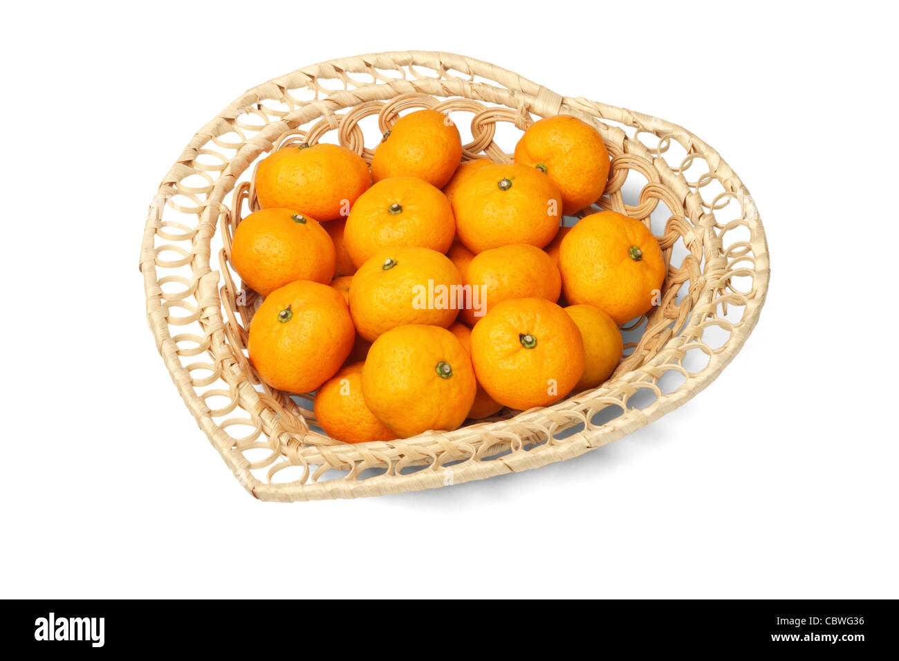 Mandarin oranges in heart shaped basket on white background Stock Photo