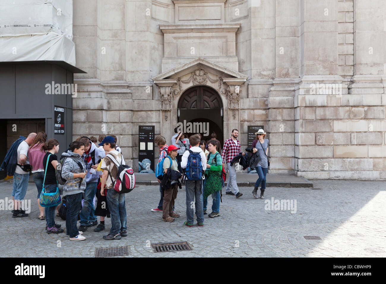 Visiting school children gather outside the side entrance to St Paul's Cathedral. Stock Photo