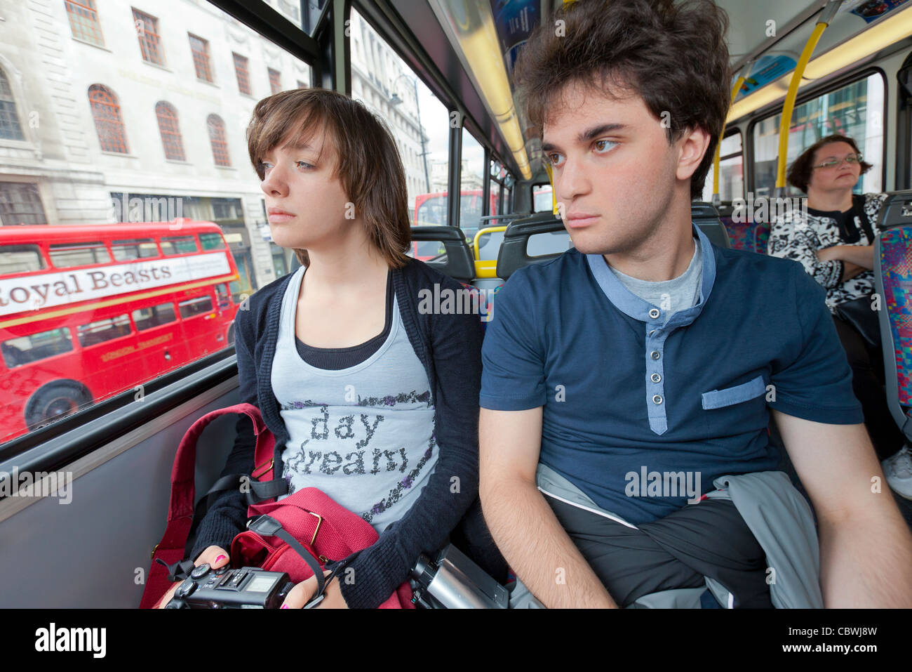 Three passengers riding on a double decker bus in Central London Stock Photo