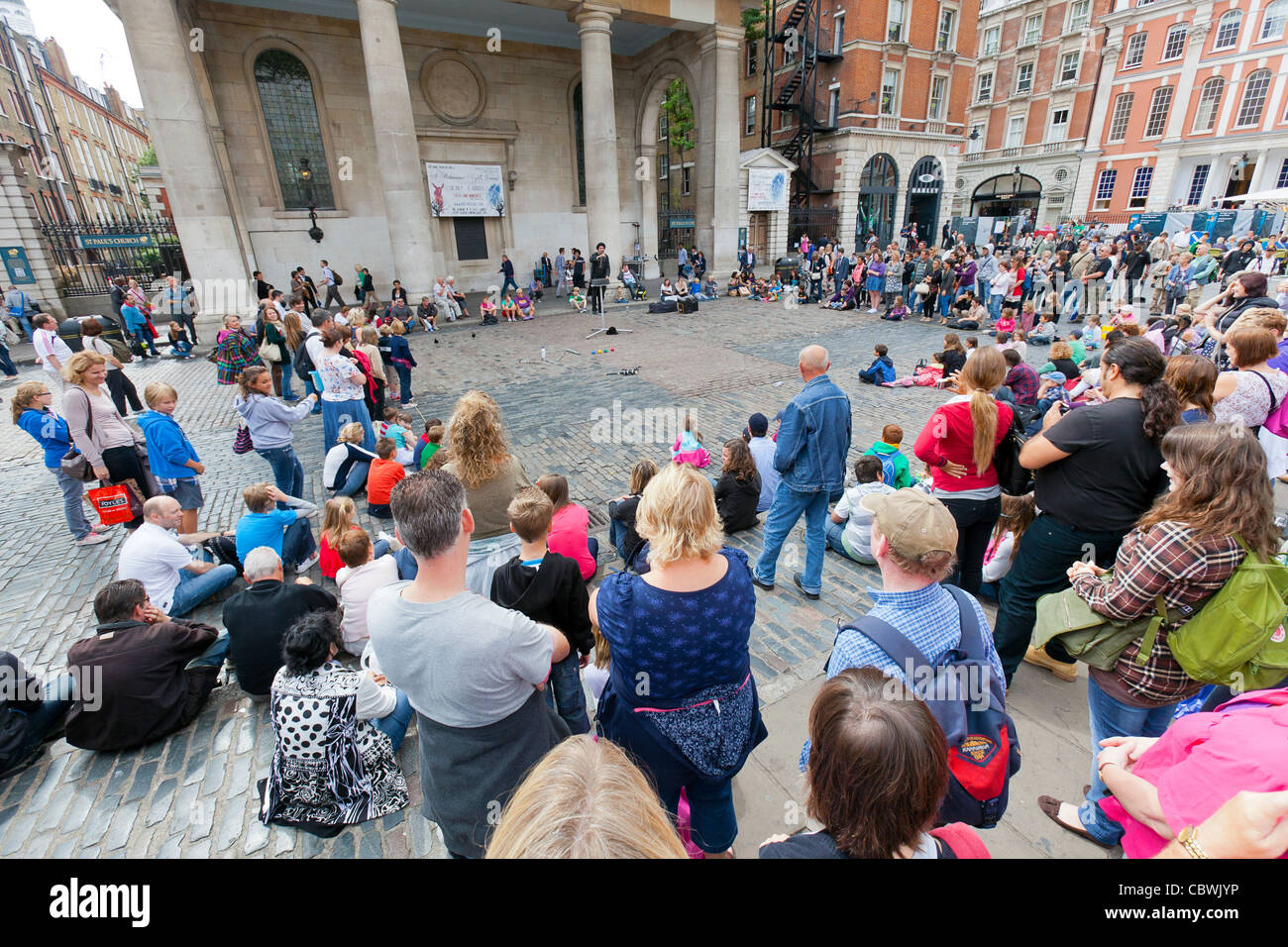 Tourists, shoppers and a street performer at Covent Garden, London, England. Stock Photo