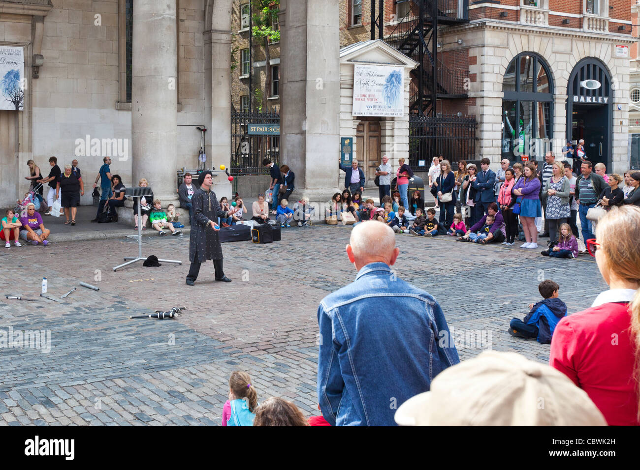 Tourists, shoppers and a street performer at Covent Garden, London, England. Stock Photo