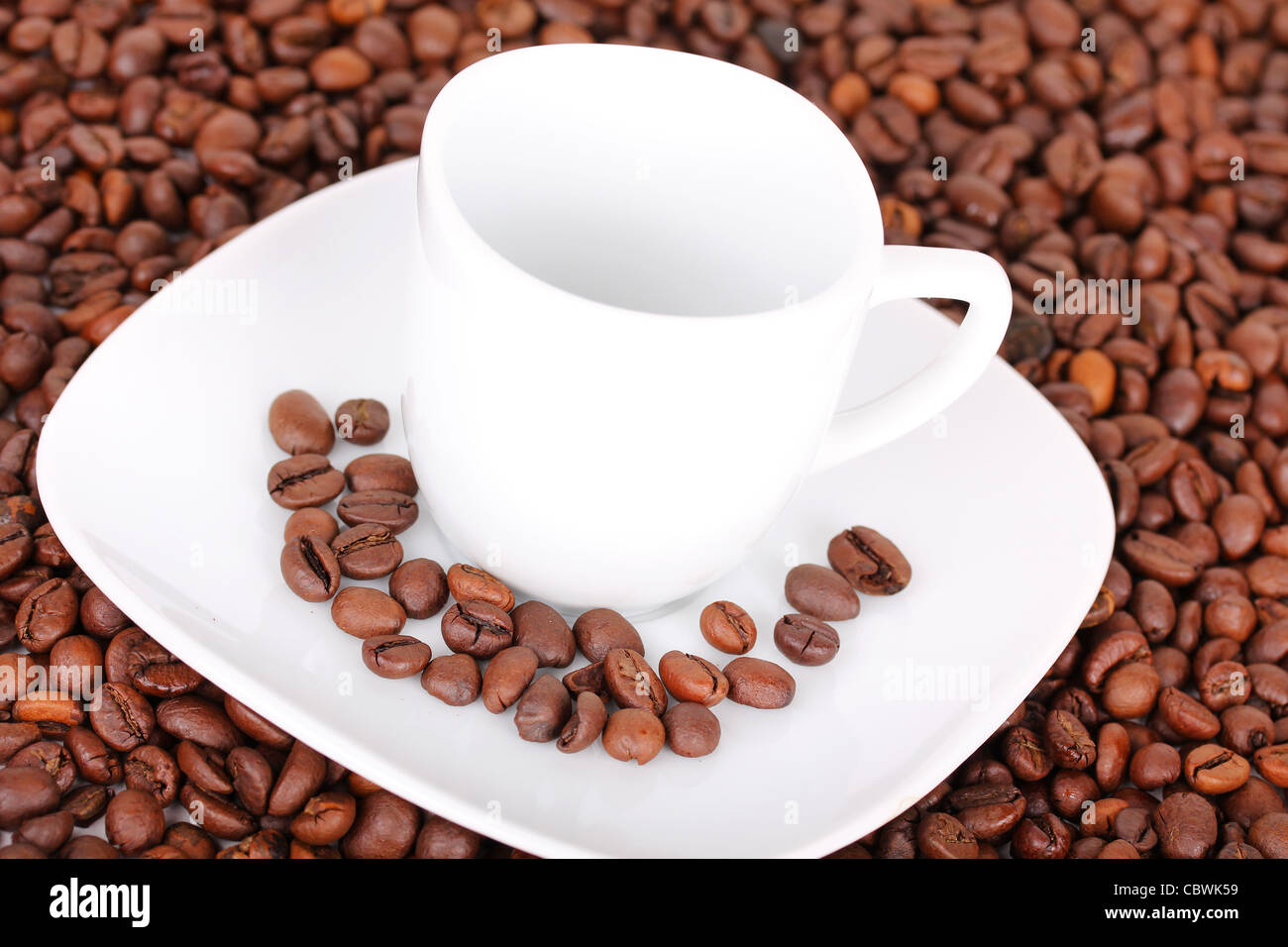 White cup in coffee beans, closeup Stock Photo
