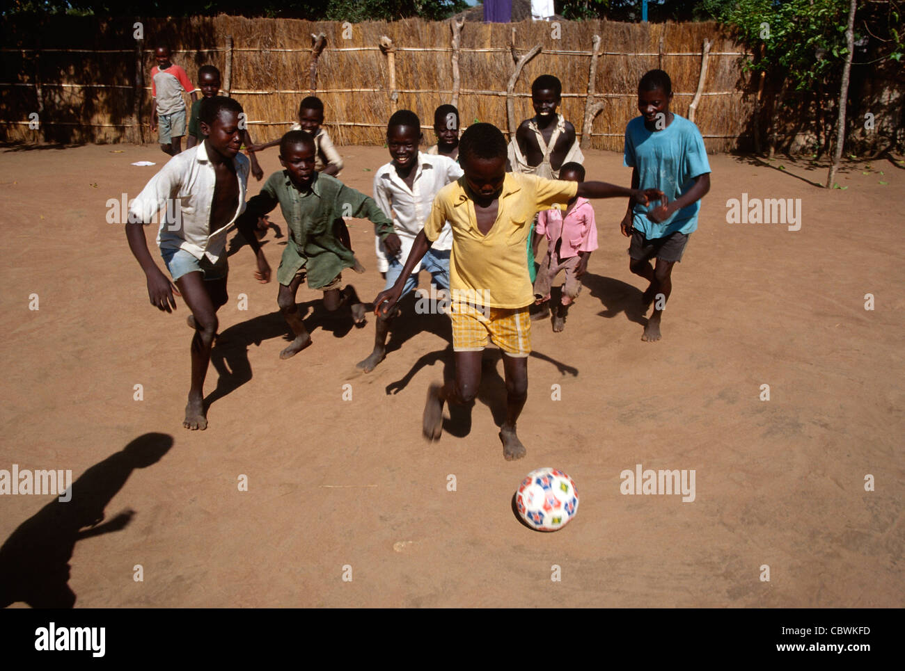 Boys playing football barefoot in a remote village in Southern Sudan