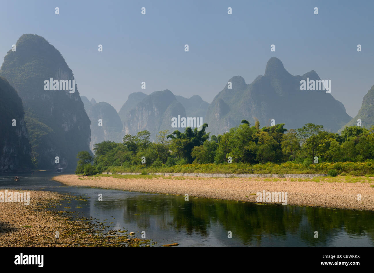 Pebble shore of the Li River with limestone Karst cones and peaks in ...