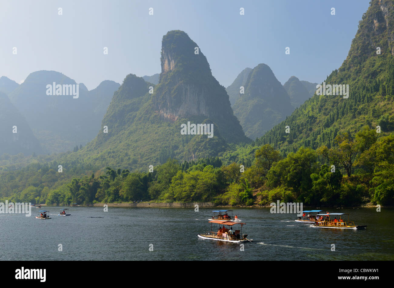 Tour boat rafts on the Li river Guangxi with pointy karst mountain peaks in the haze Peoples Republic of China Stock Photo
