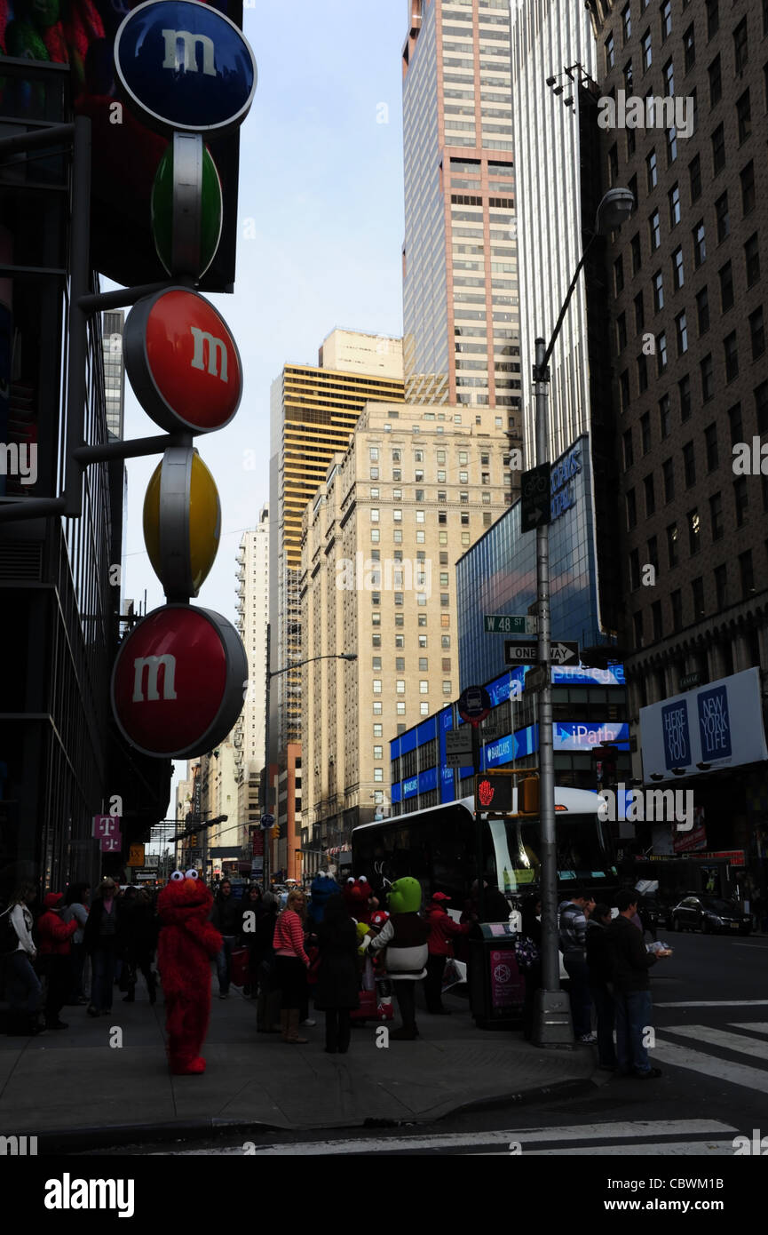 Blue sky 'urban alley' portrait people, cartoon character entertainers, front M&M Store, West 48th Street 7th Avenue, New York Stock Photo