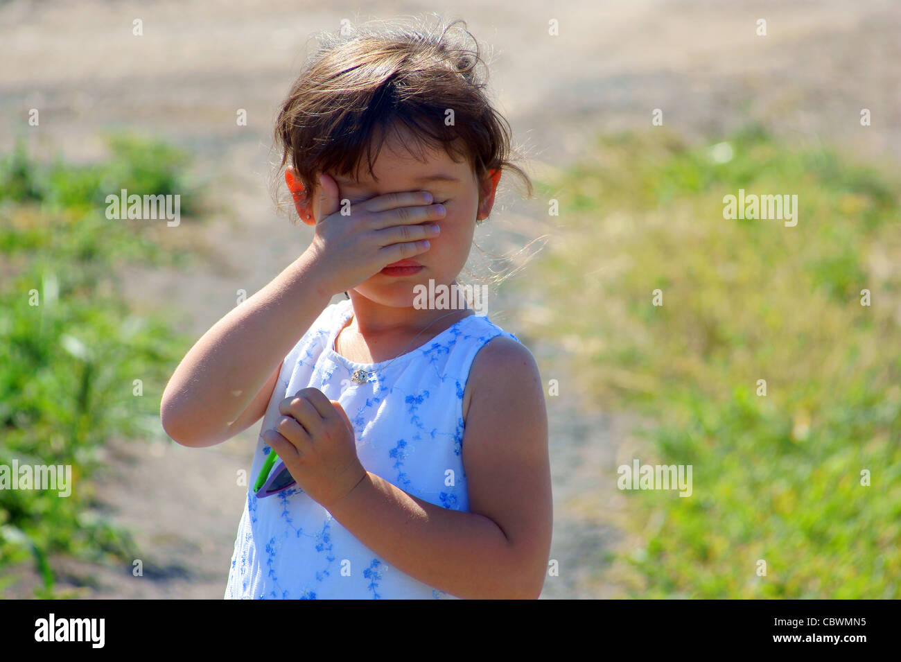 Little girl hiding, to cover eye, to cover one’s face with one’s hands ...