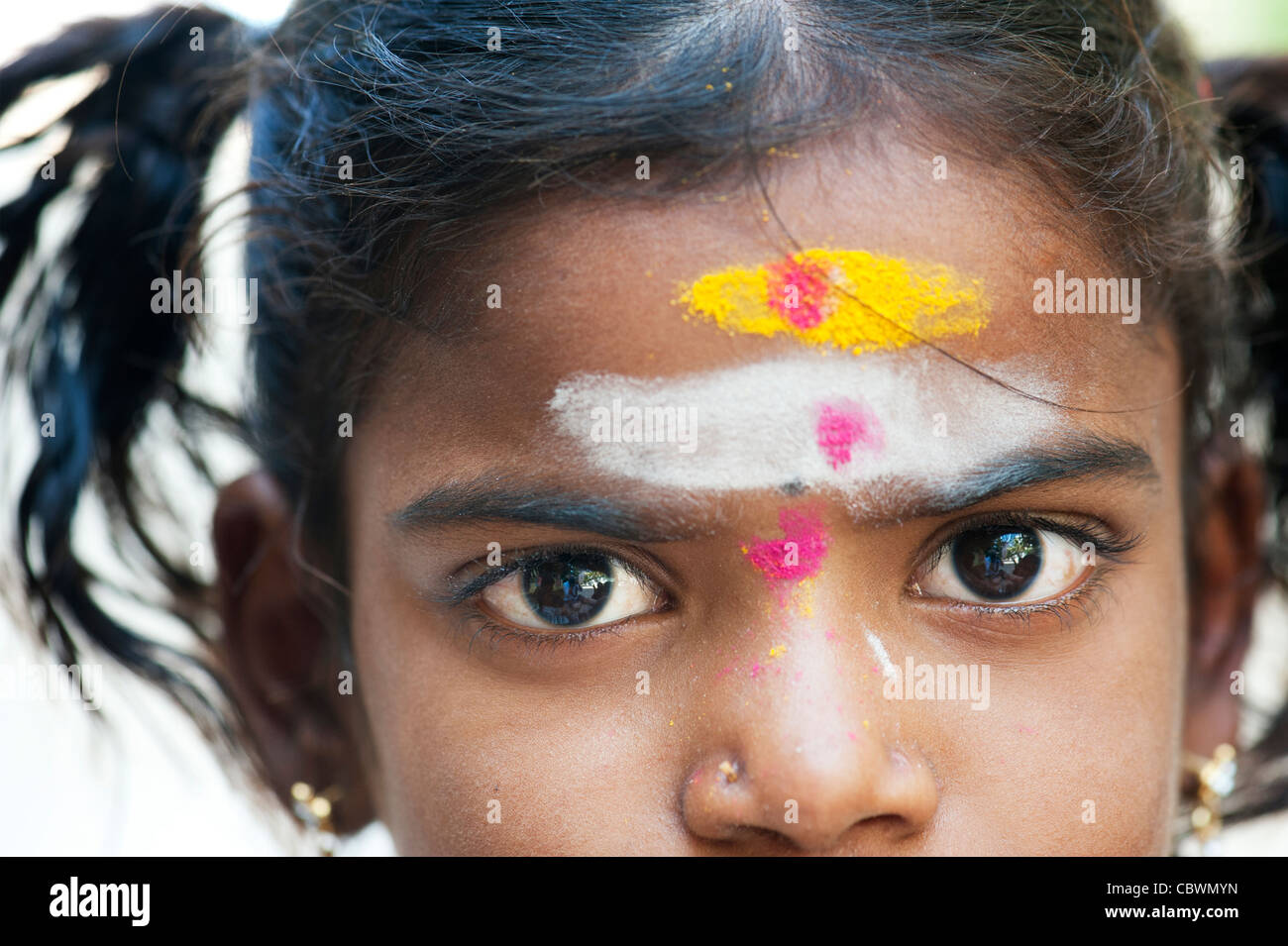 Poor Indian beggar girl dressed in religious hindu attire. Selective focus. Stock Photo