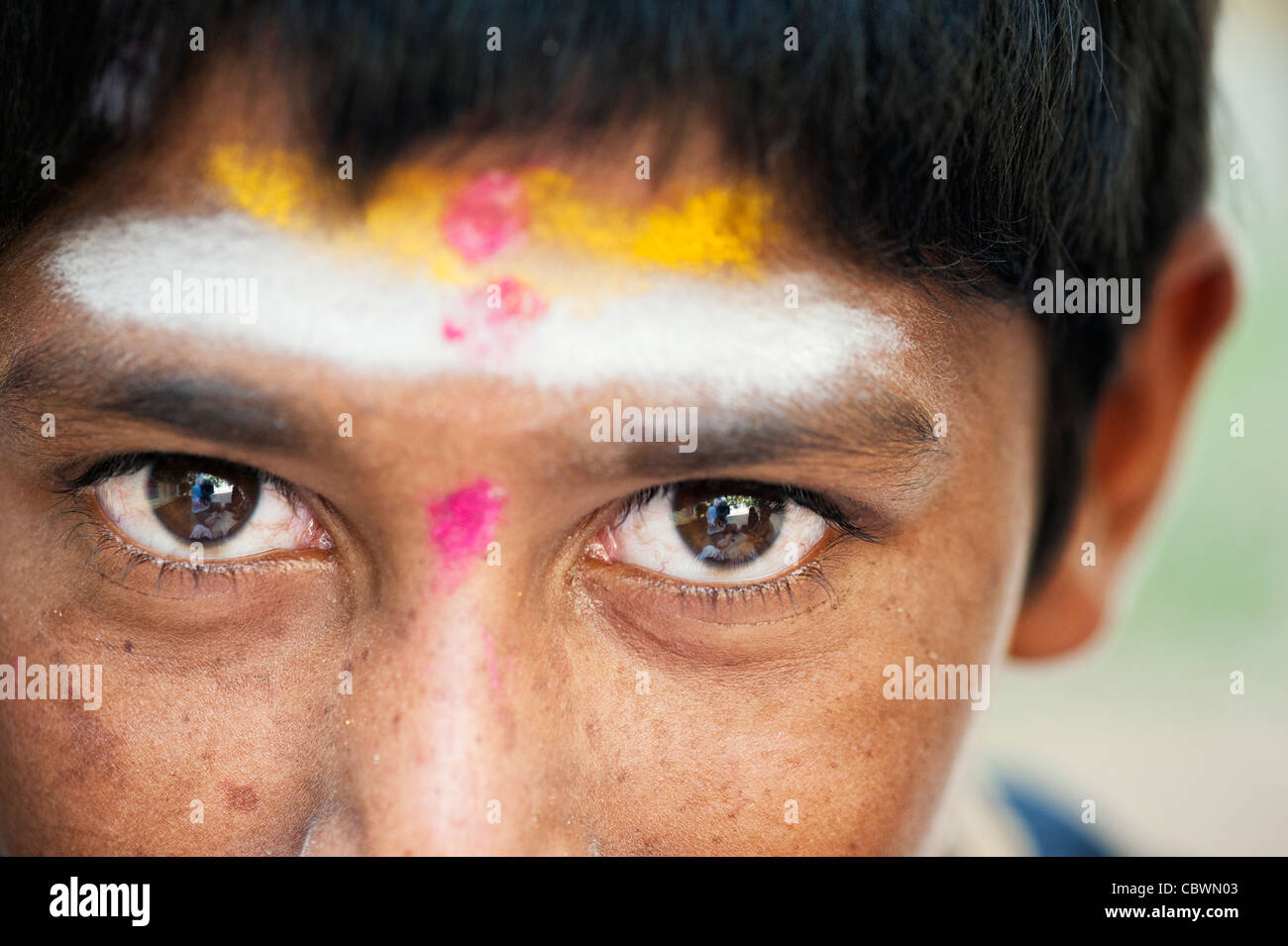 Poor Indian beggar boy dressed in religious hindu attire. Selective focus. Stock Photo
