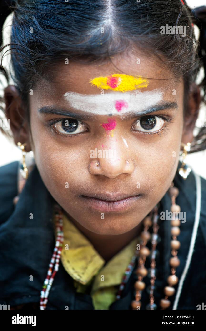 Poor Indian beggar girl dressed in religious hindu attire. Selective focus. Stock Photo