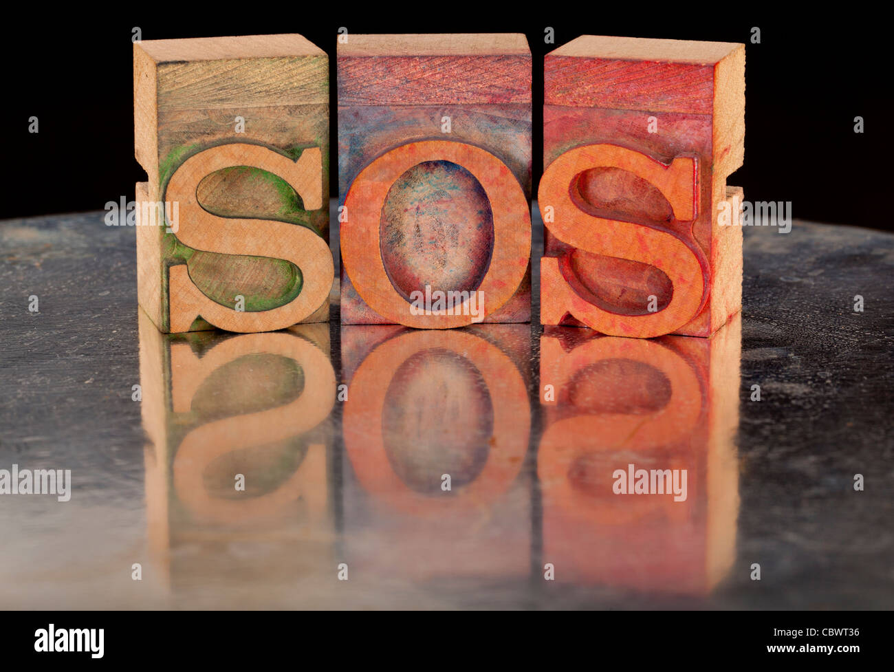 call help concept - SOS word in vintage wooden letterpress printing blocks with reflection in grunge silver surface Stock Photo
