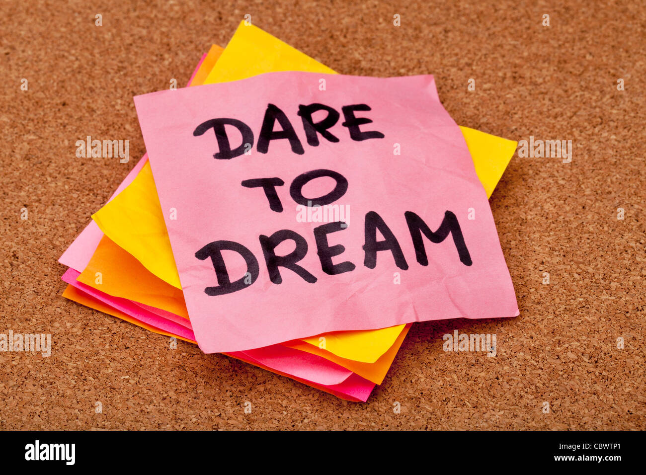 dare to dream, motivational slogan, colorful sticky notes on cork ...